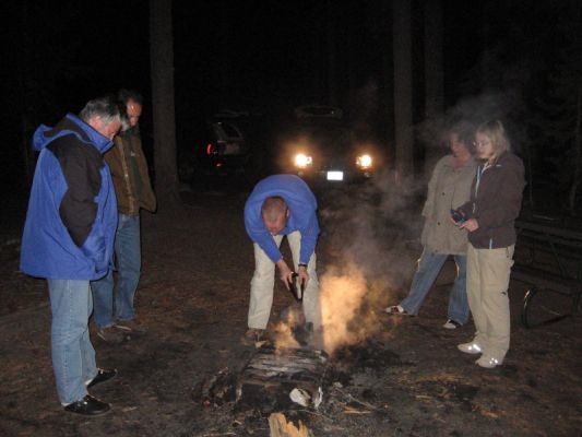 unsere Glut wird vergraben
Am Ende des Abends vergraben wir unsere Glut, damit sie in unserer Abwesenheit keinen Schaden anrichtet. Die Szenerie wird mangels Laternen oder zahlreicheren Taschenlampen mit dem Standlicht unseres Autos erhellt.
