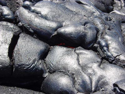 pahoehoe-Lava und in Bildmitte leuchtend-rote Lava
