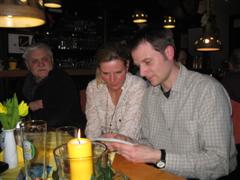 Peter sowie Rainer und Melanie, die gerade Fotos ansehen

